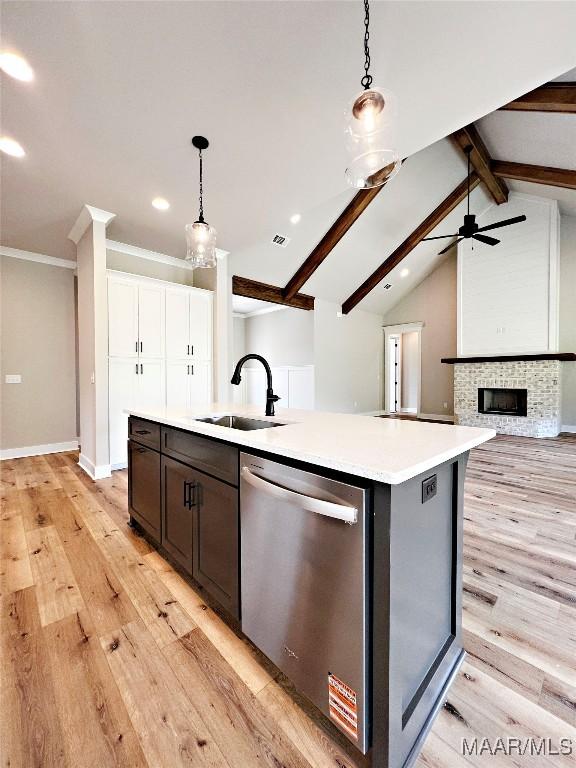 171 Mountain Laurel Rdg, Wetumpka, AL 36093 - kitchen with stainless steel dishwasher, a center island with sink, a sink, light wood finished floors, and decorative light fixtures