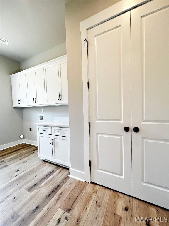 171 Mountain Laurel Rdg, Wetumpka, AL 36093 - washroom featuring washer hookup, baseboards, light wood finished floors, and cabinet space