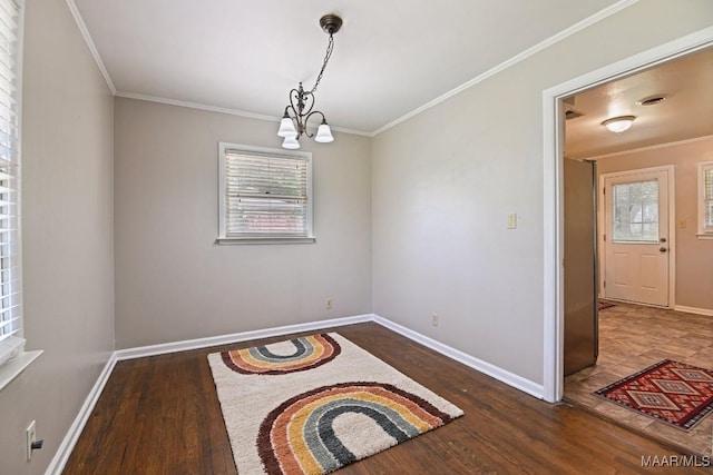 unfurnished room with baseboards, a chandelier, plenty of natural light, and wood finished floors