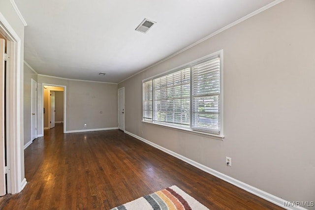 unfurnished room featuring baseboards, ornamental molding, wood finished floors, and visible vents