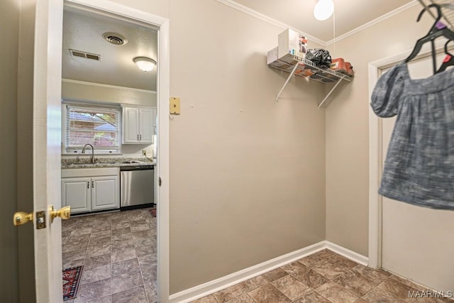 spacious closet featuring a sink, stone finish flooring, and visible vents