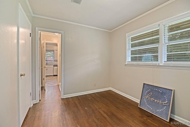 unfurnished room featuring baseboards, ornamental molding, dark wood finished floors, and visible vents