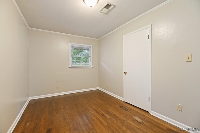 unfurnished room with crown molding, baseboards, wood finished floors, and visible vents
