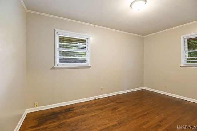 spare room featuring crown molding, baseboards, and dark wood-style floors