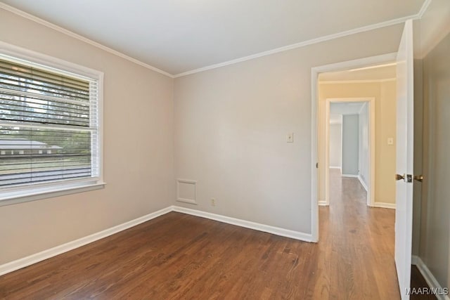 unfurnished room with baseboards, crown molding, and wood finished floors