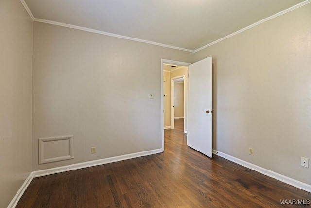 spare room with baseboards, ornamental molding, and dark wood-style flooring