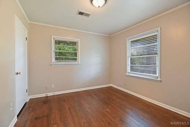 spare room featuring baseboards, a wealth of natural light, wood finished floors, and visible vents
