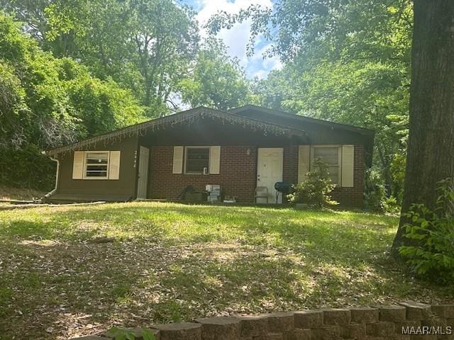 single story home featuring brick siding
