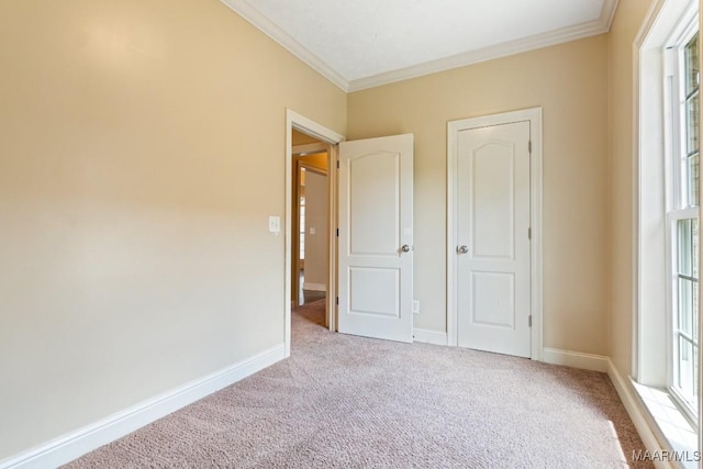 unfurnished bedroom featuring carpet floors, ornamental molding, and baseboards