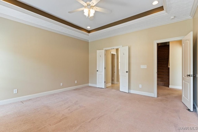 unfurnished bedroom featuring recessed lighting, ornamental molding, a raised ceiling, and light carpet