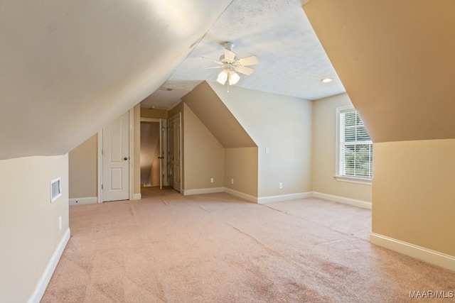 additional living space with visible vents, light carpet, and lofted ceiling