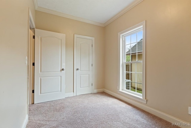 unfurnished bedroom featuring carpet floors, ornamental molding, and baseboards