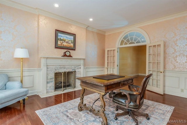 office with french doors, wainscoting, wood finished floors, ornamental molding, and a premium fireplace