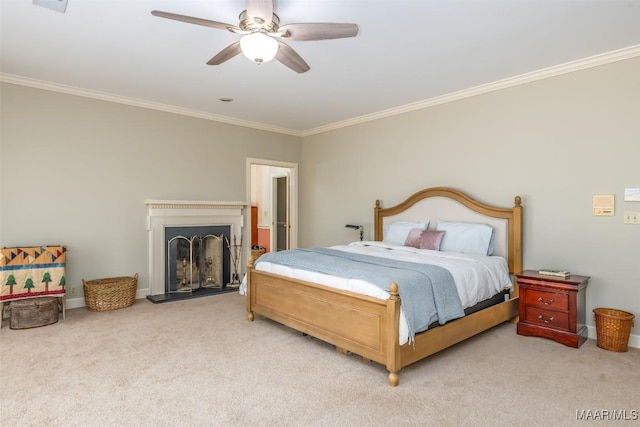 bedroom with carpet floors, a fireplace with raised hearth, crown molding, and ceiling fan