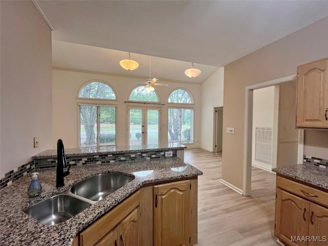 kitchen featuring plenty of natural light, a sink, dark stone countertops, and a ceiling fan