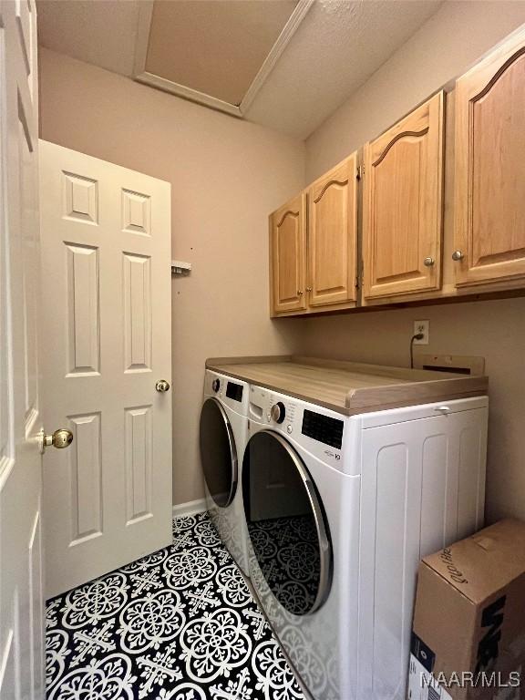 laundry area featuring attic access, cabinet space, and washing machine and clothes dryer