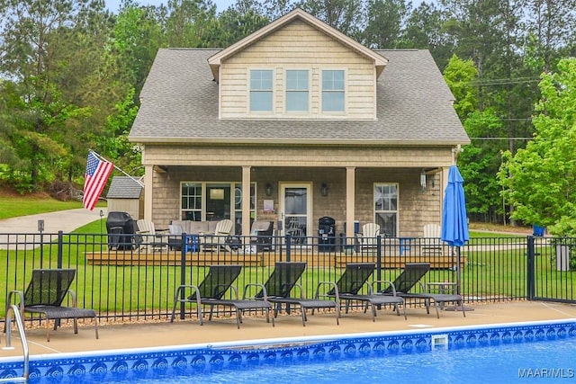 view of swimming pool featuring a yard, a patio, a fenced in pool, and fence