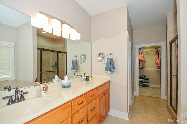 full bath with a sink, a walk in closet, a stall shower, and double vanity