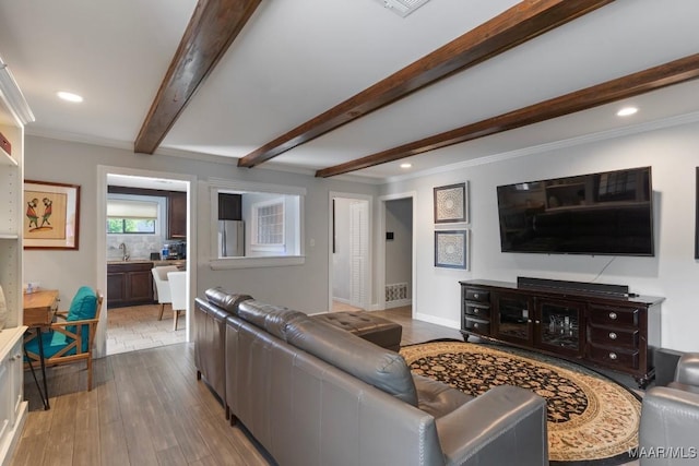 living area featuring crown molding, recessed lighting, baseboards, wood finished floors, and beamed ceiling