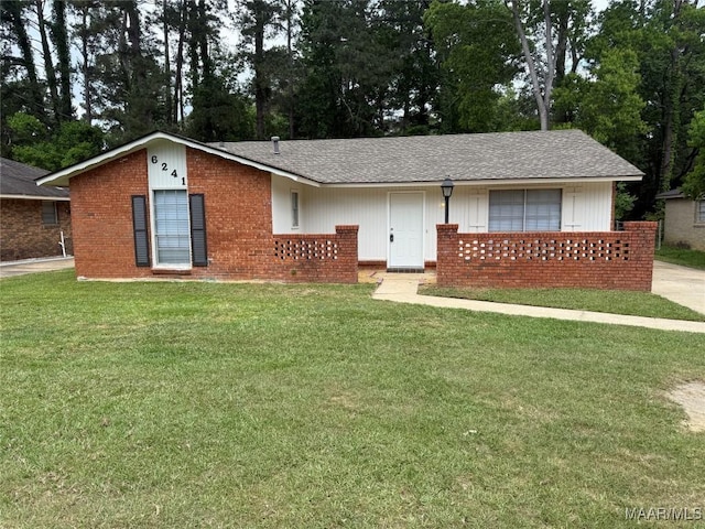 ranch-style house featuring a shingled roof, brick siding, and a front yard