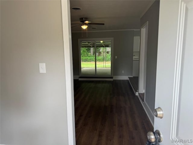 hallway featuring crown molding, baseboards, dark wood-style floors, and visible vents
