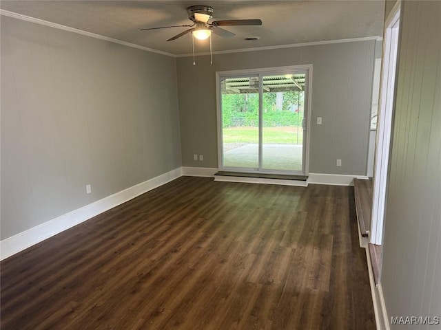 spare room featuring a ceiling fan, baseboards, ornamental molding, and dark wood-type flooring