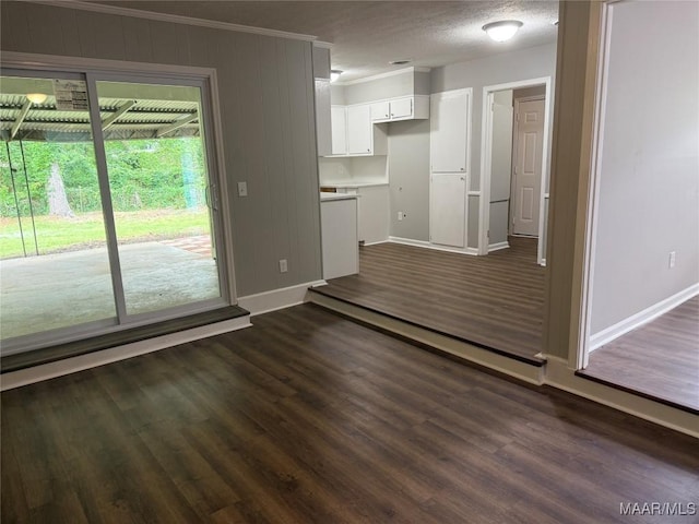 unfurnished living room with crown molding, dark wood-style flooring, and baseboards