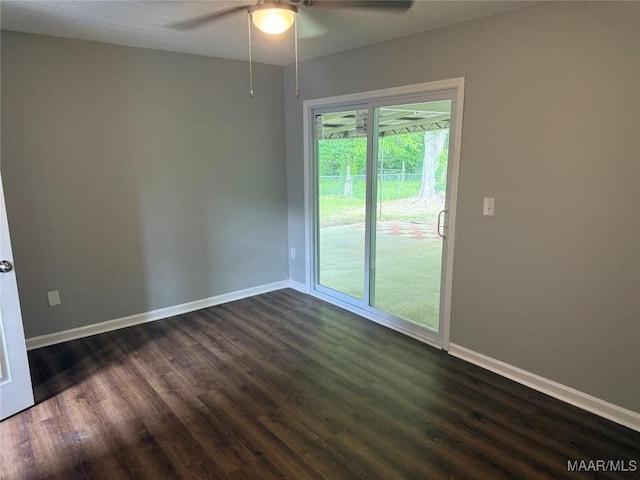 unfurnished room with baseboards, a ceiling fan, and dark wood-style floors
