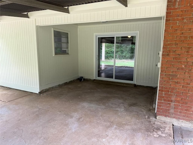 exterior space with beamed ceiling and unfinished concrete flooring