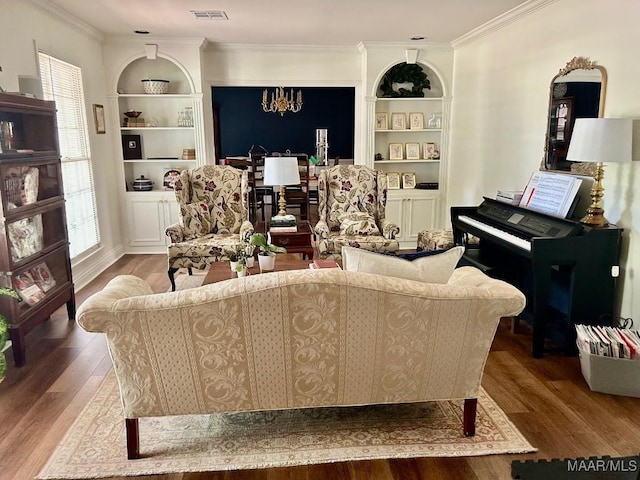 living area featuring crown molding, visible vents, built in features, and wood finished floors