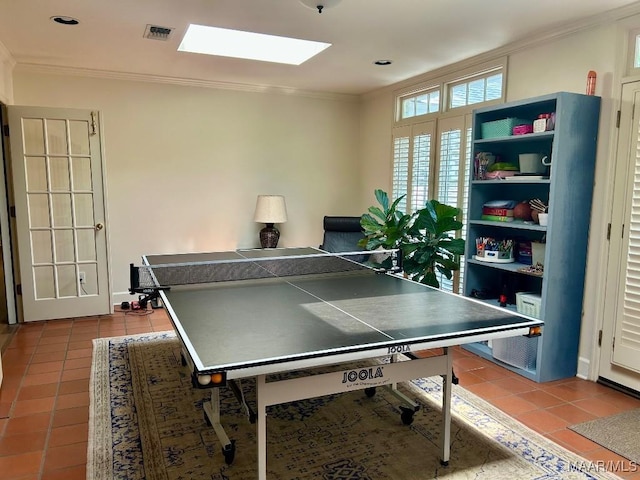 recreation room with visible vents, ornamental molding, tile patterned floors, and a skylight