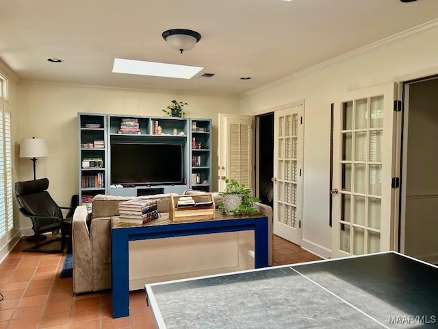living area featuring crown molding, a skylight, baseboards, and tile patterned flooring