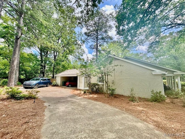 view of home's exterior featuring driveway and brick siding