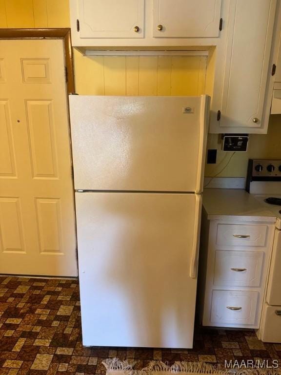 3008 Baffin Dr, Montgomery, AL 36110 - kitchen featuring white cabinets, light countertops, brick patterned floor, freestanding refrigerator, and range with electric stovetop
