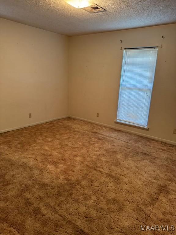 3008 Baffin Dr, Montgomery, AL 36110 - carpeted spare room featuring a textured ceiling, visible vents, and baseboards