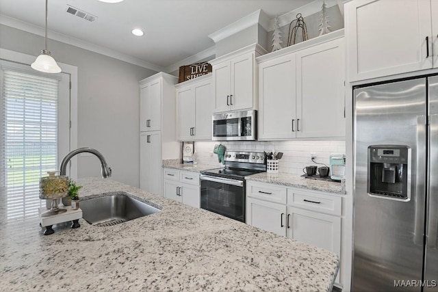 kitchen featuring tasteful backsplash, a sink, ornamental molding, stainless steel appliances, and white cabinetry