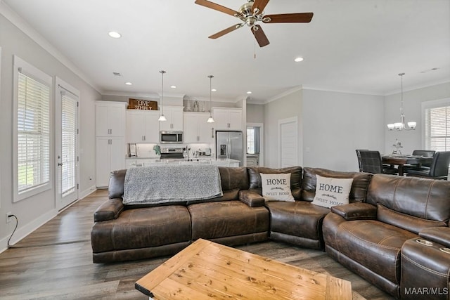 living area featuring recessed lighting, crown molding, dark wood finished floors, and ceiling fan with notable chandelier