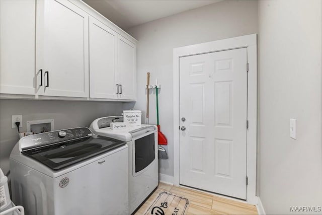 washroom featuring light wood-style floors, cabinet space, baseboards, and washer and dryer