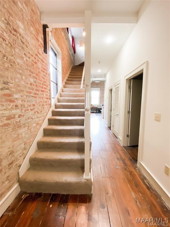 246 N Court St Unit J, Montgomery, AL 36104 - stairway with baseboards, hardwood / wood-style flooring, and brick wall