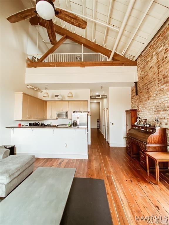 246 N Court St Unit J, Montgomery, AL 36104 - living area with high vaulted ceiling, ceiling fan, light wood-type flooring, and brick wall