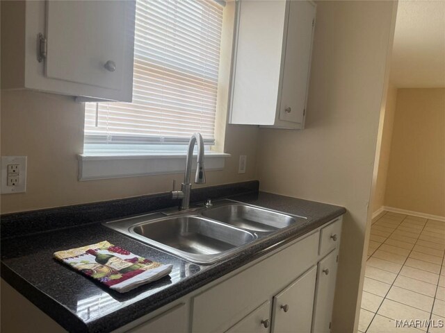 6253 S Hampton Dr, Montgomery, AL 36116 - kitchen with a sink, white cabinetry, light tile patterned floors, and dark countertops
