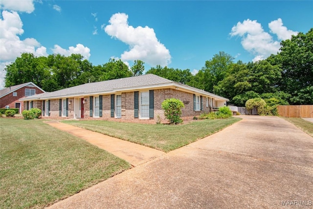 single story home featuring brick siding, fence, driveway, and a front yard