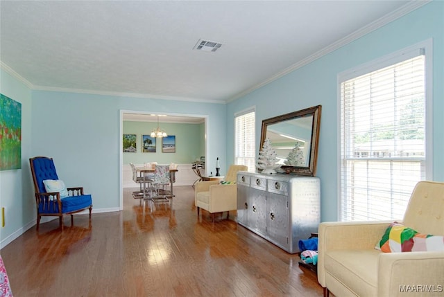 sitting room featuring a chandelier, a wealth of natural light, and wood finished floors