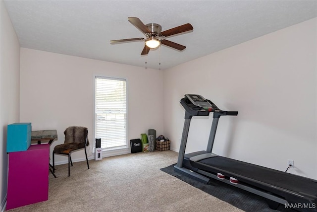 exercise room with baseboards, carpet flooring, and a ceiling fan