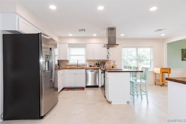 206 Choctaw Dr, Montgomery, AL 36117 - kitchen with stainless steel appliances, island range hood, a sink, a peninsula, and white cabinetry