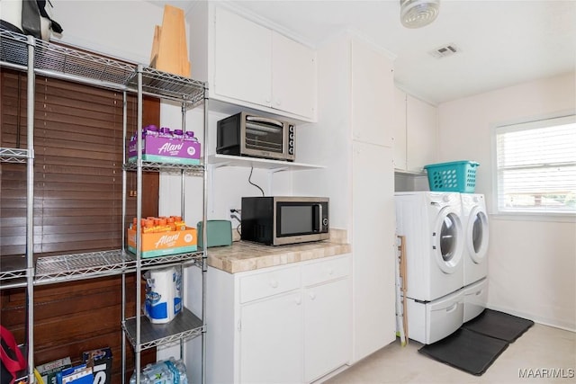 clothes washing area featuring laundry area, washing machine and dryer, and visible vents