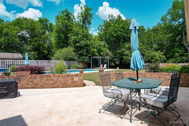 view of patio / terrace with a fenced in pool, a fenced backyard, and outdoor dining space