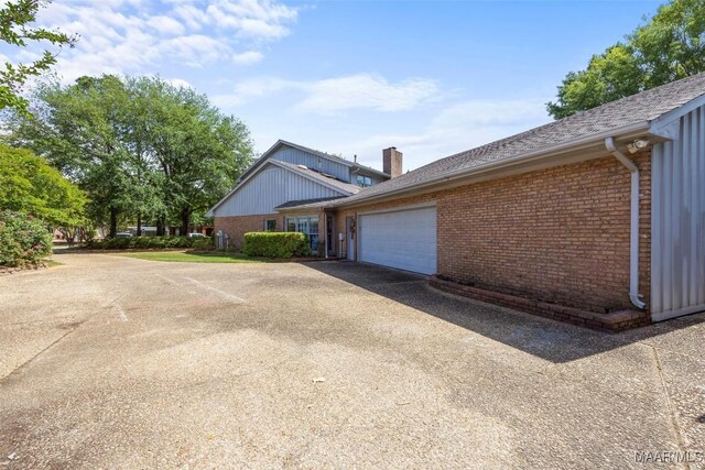 1520 Meriwether Rd, Montgomery, AL 36117 - view of side of property featuring brick siding, a garage, driveway, and a chimney