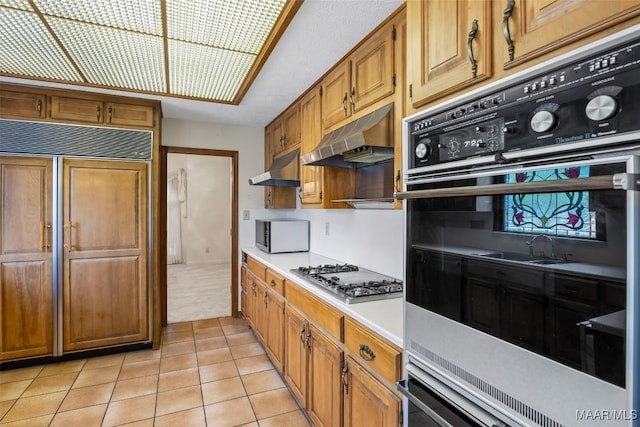 1520 Meriwether Rd, Montgomery, AL 36117 - kitchen with stainless steel gas stovetop, light countertops, under cabinet range hood, and paneled fridge
