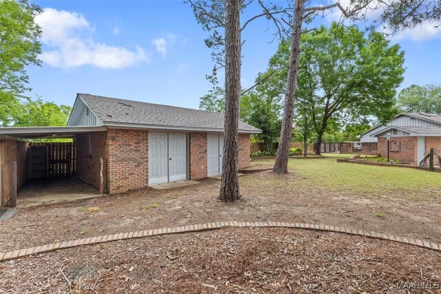 1520 Meriwether Rd, Montgomery, AL 36117 - rear view of property featuring brick siding, a carport, and roof with shingles